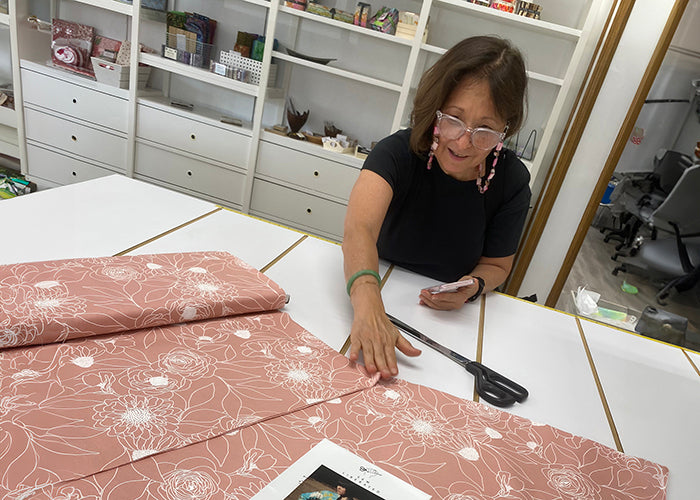 Woman working with fabric at a table in a workshop setting