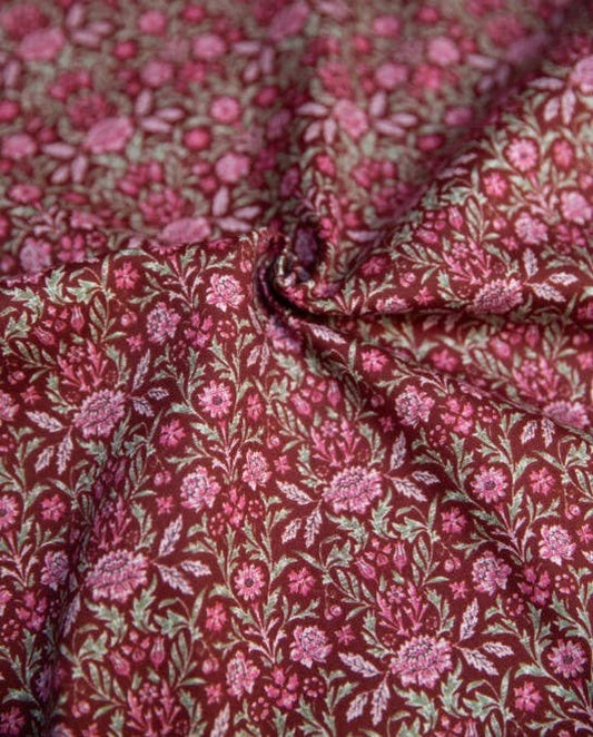 Close-up of floral fabric with pink and green flowers on a red background