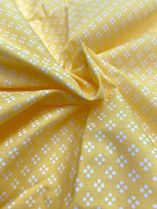 Yellow fabric with small white floral patterns